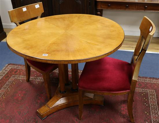 A Biedermeier circular topped satin birch table and a pair of chairs W.97cm